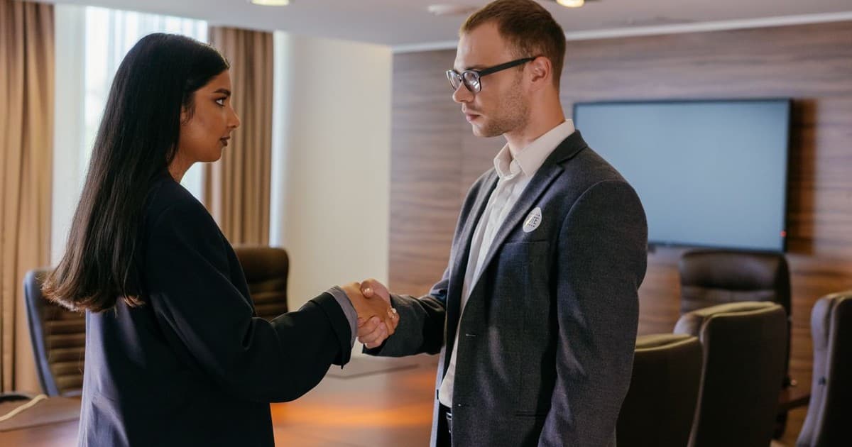 Two professionals shaking hands after an academy credential discussion