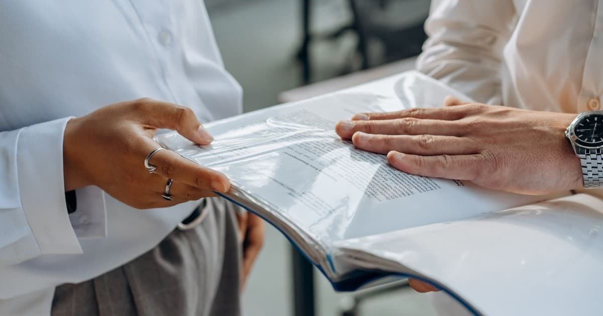 Two professionals reviewing a credential guide document together