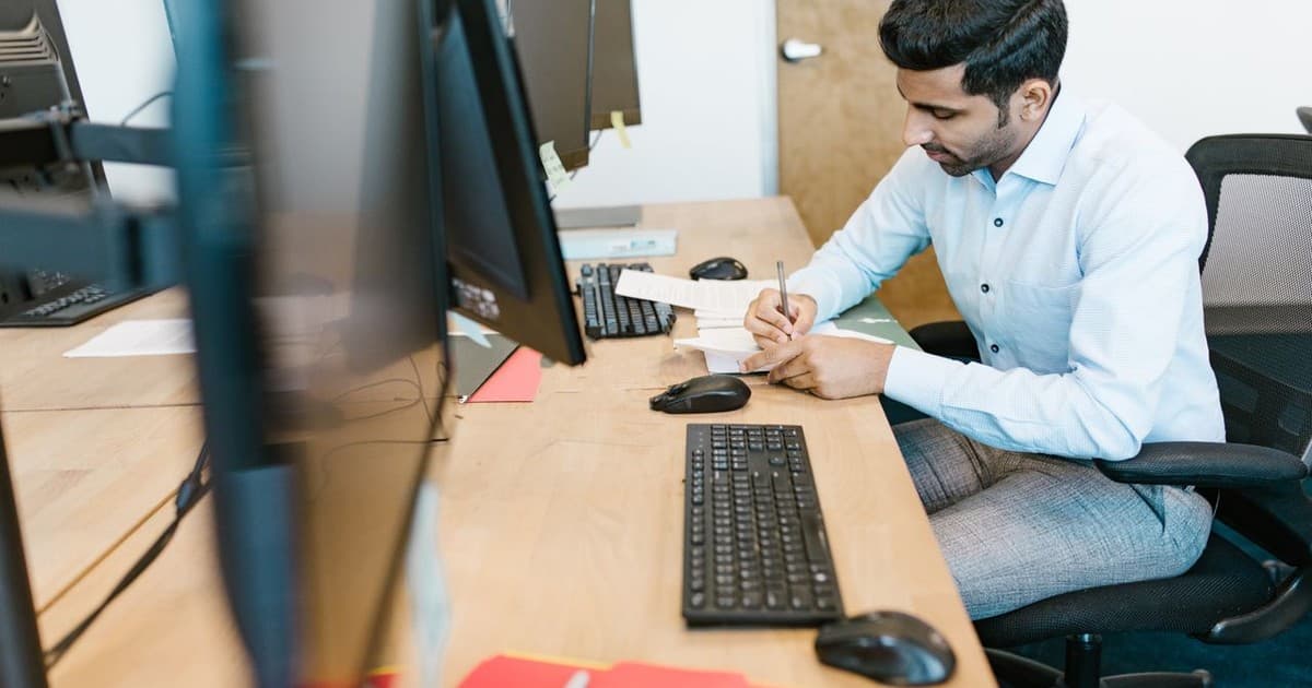 Professional writing structured course notes at a desk in a training institute